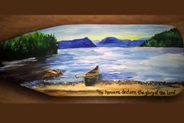 a paddle with a scene of a lake and a canoe